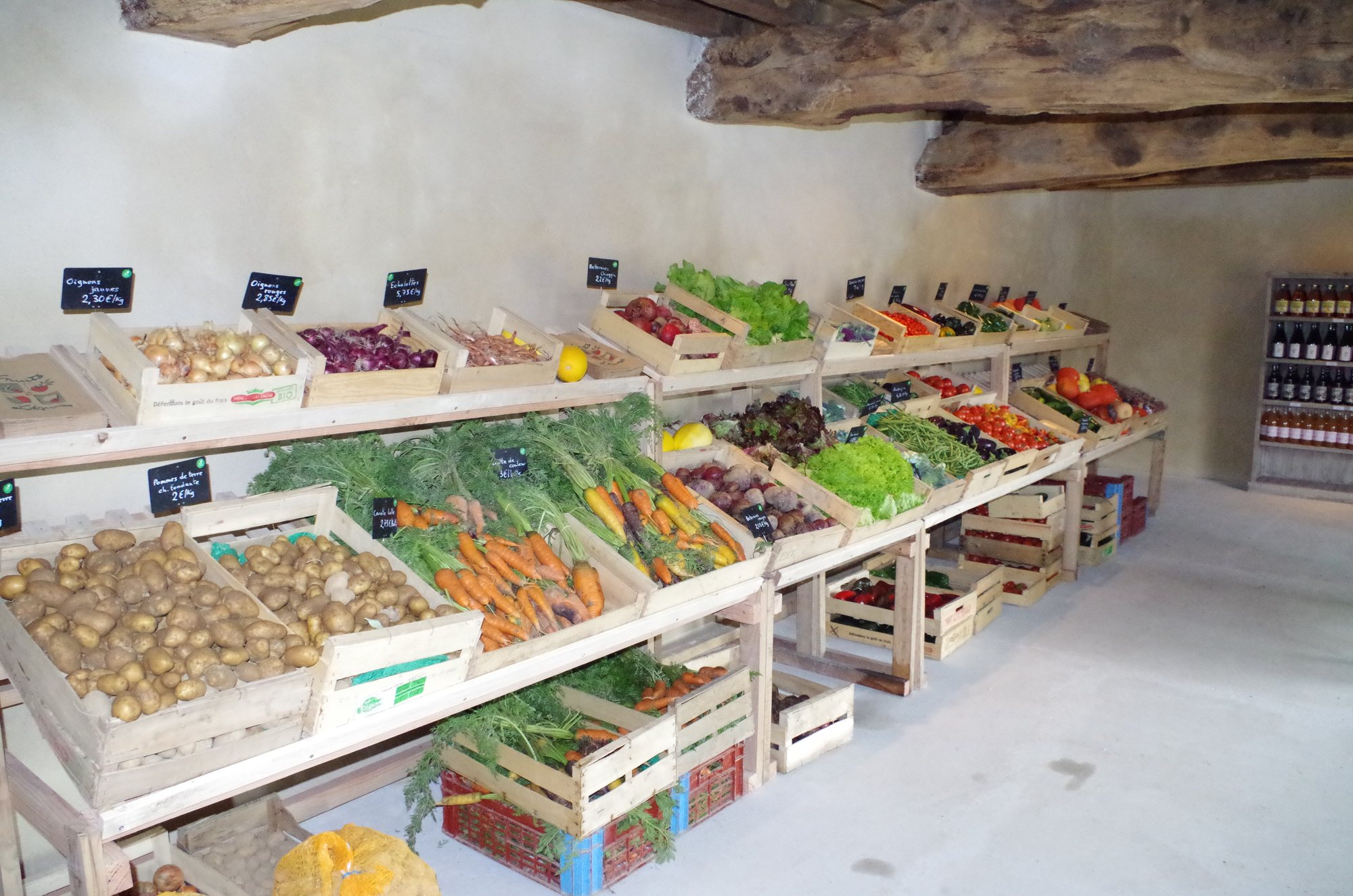 Étals de légumes bio en cagettes dans le magasin de la ferme
